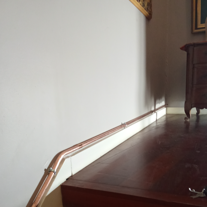 Cheminement esthétique d'un tuyau en cuivre le long d'une plinthe intérieure pour une installation et entretien gaz par l'expert LIMA à Mées.
