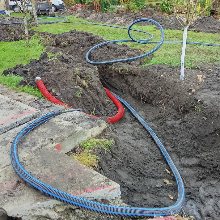 Déploiement de gaines de raccordement dans une tranchée de jardin pour la viabilisation d'un terrain à Seyresse par l'entreprise de plomberie LIMA.