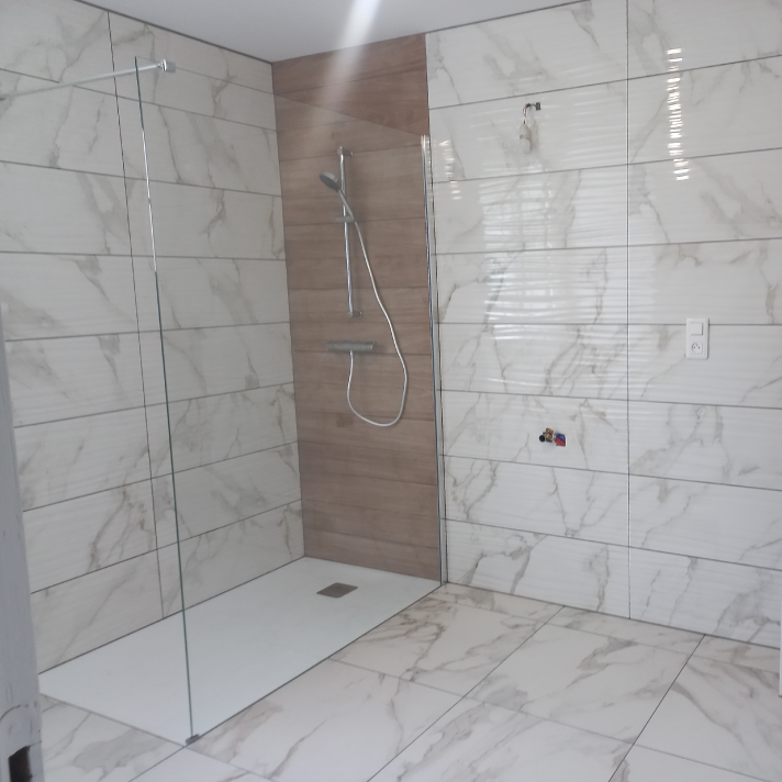 Création d'une douche spacieuse avec paroi vitrée et faïence imitation marbre par l'artisan plombier LIMA à Narrosse, près de Dax.