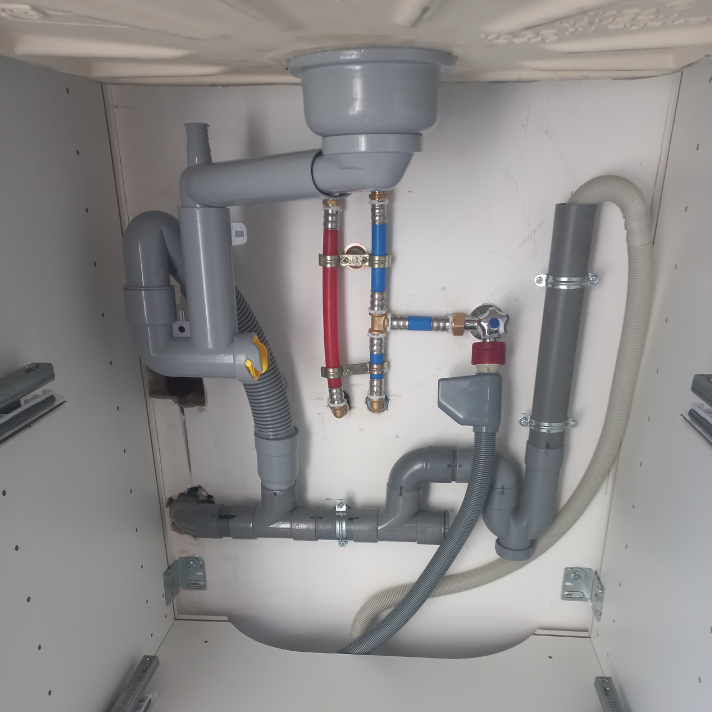 Raccordement soigné et mise aux normes des évacuations PVC et des arrivées d'eau sous un évier de cuisine à Dax par votre plombier LIMA.